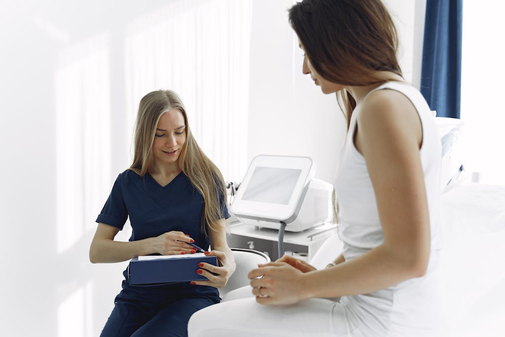 Nurse helping a female patient during a check-up in a modern, bright clinic setting.