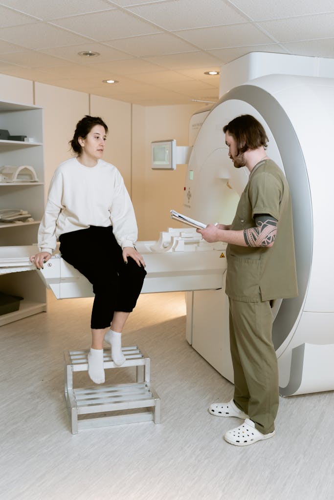 A medical technician consulting with a patient during an MRI procedure in a healthcare facility.